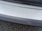 a close up of a car ' s bumper on a gravel road