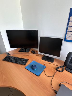 a desk with two computers and a laptop on it