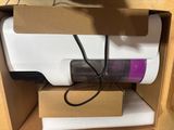 a white and purple vacuum in a cardboard box