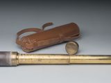 un vieux télescope en laiton avec un étui en cuir et un étui en cuir