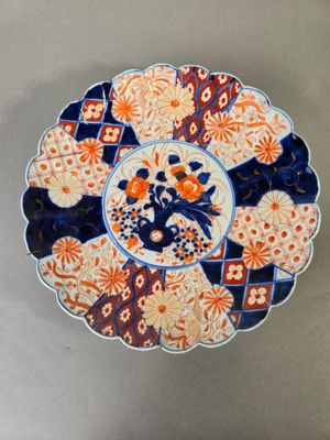 une assiette orange et bleue décorée de fleurs, posée sur une table