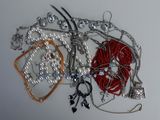many different types of necklaces and bracelets laid out on a table