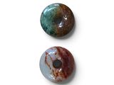 trois beignets de couleurs et de formes différentes posés sur une surface blanche