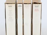 trois livres sont empilés sur une surface blanche