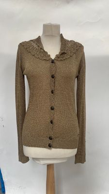 brown cardigan sweater on a mannequin stand with a blue chair