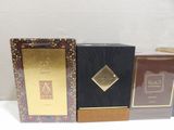 three boxes of perfume are lined up on a white surface