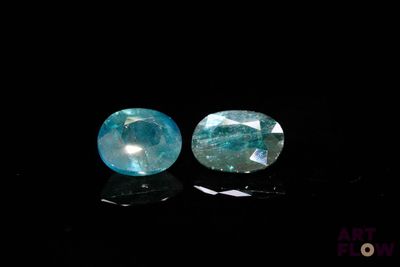 deux morceaux de topaze bleue reposent sur une surface noire