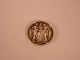 a silver coin with a picture of a group of people on it