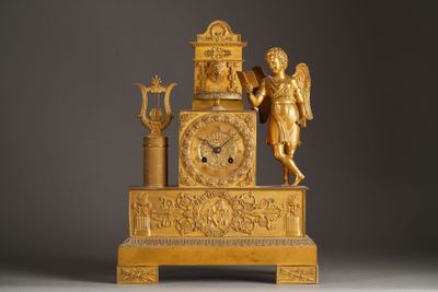 a gold clock with an angel on top of it