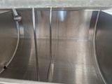 un grand saladier en inox muni d'une poignée, dans la cuisine