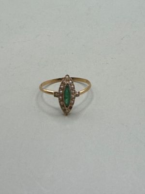 a close up of a gold ring with a green stone