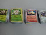 Quatre types différents de cartes Pokémon sont alignées sur une table