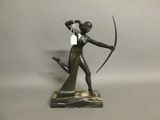 statue of a woman holding a bow and arrow on a marble base