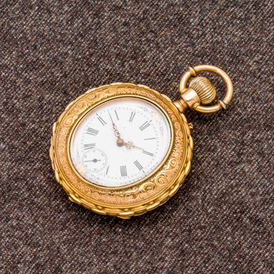 une montre de poche en or avec des chiffres romains