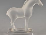 un cheval blanc posé sur un socle transparent