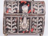 an old silver and black box with red flowers on it