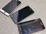 three cell phones are sitting on the floor next to each other