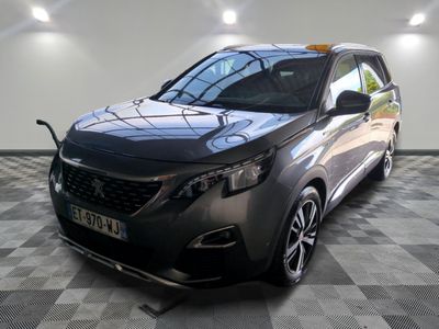la voiture grise est garée sur un sol en damier dans le garage