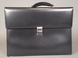 a black leather briefcase sitting on top of a white table