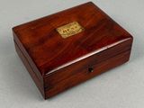 a small wooden box with a brass plate on top of it