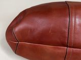 brown leather football ball on a white surface with a white background