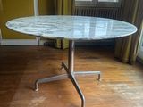 une table au plateau en marbre au milieu d'un parquet