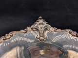 a silver plate with a clock on it on a table