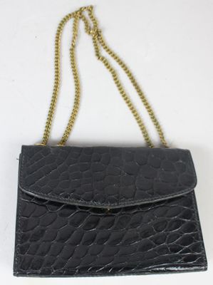 une image représentant un sac à main noir auquel est suspendue une chaîne