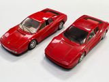 deux petites voitures rouges posées l'une à côté de l'autre sur une surface blanche