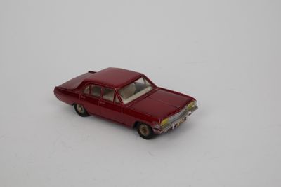 une petite voiture rouge posée sur une surface blanche