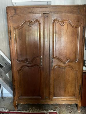 a wooden armoire in a room with a red rug