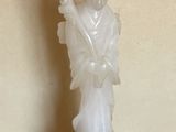 une statue représentant une femme tenant un éventail, posée sur une table