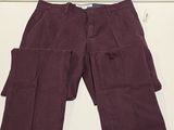 un gros plan sur un pantalon violet posé sur une surface blanche