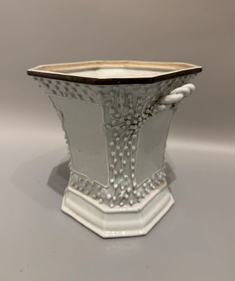 un vase blanc bordé de noir posé sur une table