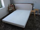 un lit avec un matelas dans une chambre dotée d'une fenêtre