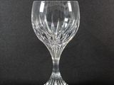 a clear glass wine goblet on a black background