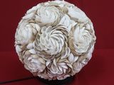 une boule blanche ornée de fleurs sur un fond rouge