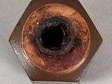 a rusted metal nut on a white surface