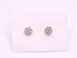 une paire de boucles d'oreilles en diamant posée sur une carte blanche