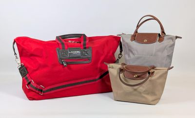 three bags of different colors are lined up on a white surface