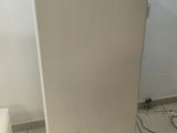 a white refrigerator sitting in a room with a chalkboard on the wall