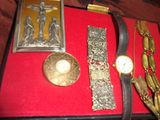 une boîte rouge sur laquelle sont posés une montre, un bracelet et d'autres objets