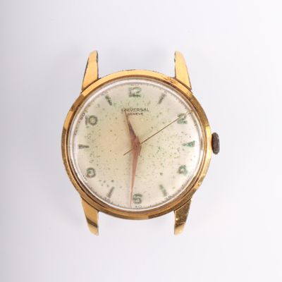 gros plan d'une montre-bracelet en or sur une surface blanche