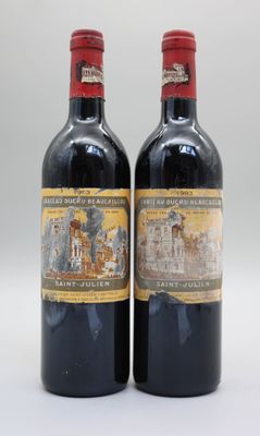 deux bouteilles de vin rouge posées l'une à côté de l'autre sur une surface blanche