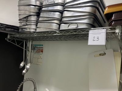 Plusieurs casseroles et poêles sont empilées sur une étagère dans un magasin