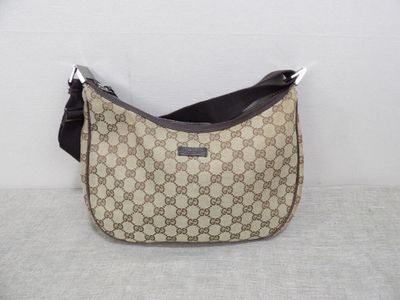 beige and black guccissi bag on a white surface