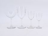 several empty wine glasses are lined up on a white surface