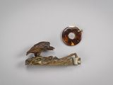 une image représentant une paire de broches avec un oiseau perché sur une branche