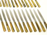 eight knives are lined up in a row on a white surface