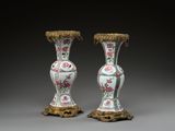paire de vases chinois ornés de motifs floraux, posés sur des socles, sur fond gris
